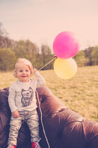 toddler boy holding balloons 
