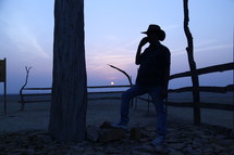 silhouette of a cowboy standing in a desert 