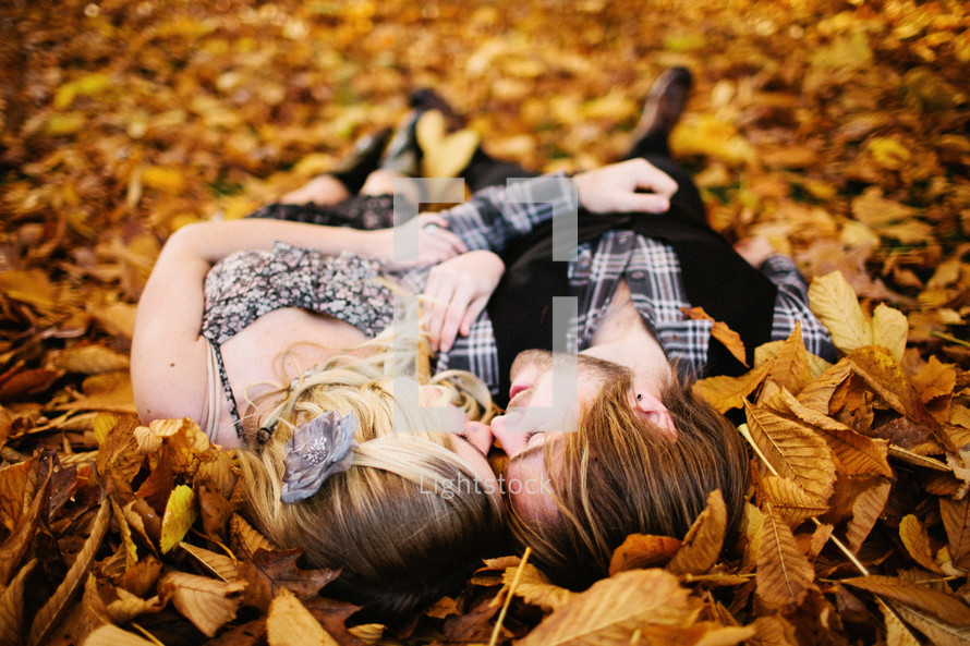 couple lying in a pile of leaves