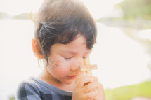 toddler girl holding a wooden cross 