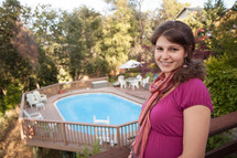 woman standing outdoors in front of a pool 