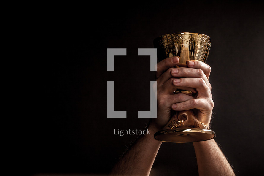 Hands holding up a communion goblet.