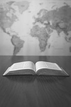 world map and open Bible on a desk 