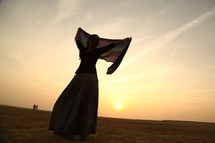 woman dancing with a scarf in the desert 