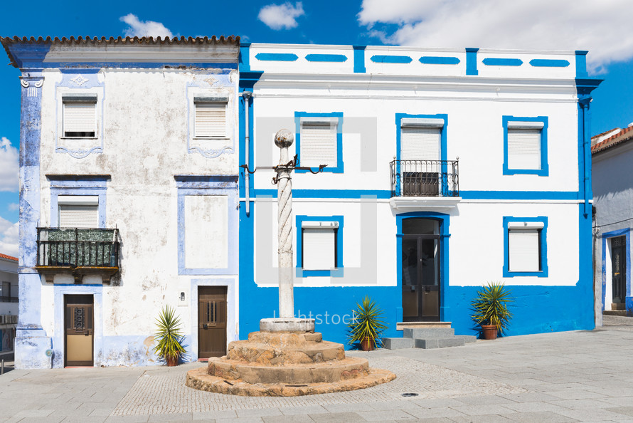 blue, white, painted, buildings, along, cobblestone, road, courtyard, balconies 
