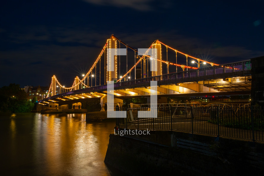 lights on a bridge in a city over a river at night 