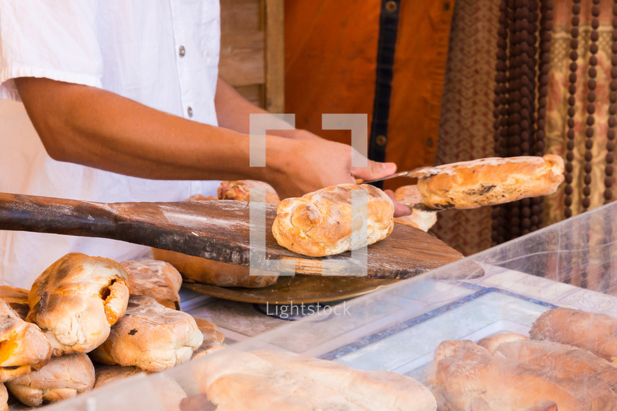 Two men baking sausage filled bread. typical product of portugal.
