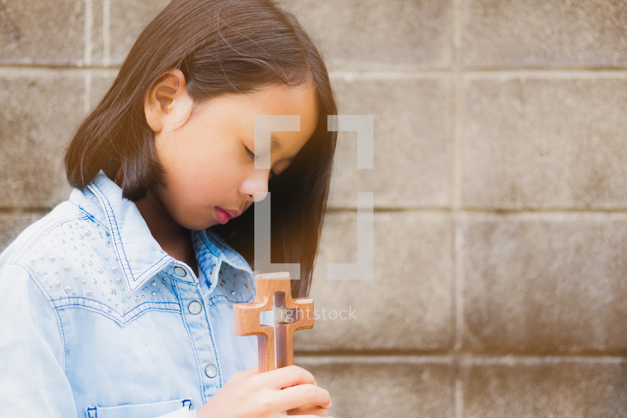 girl holding a wooden cross