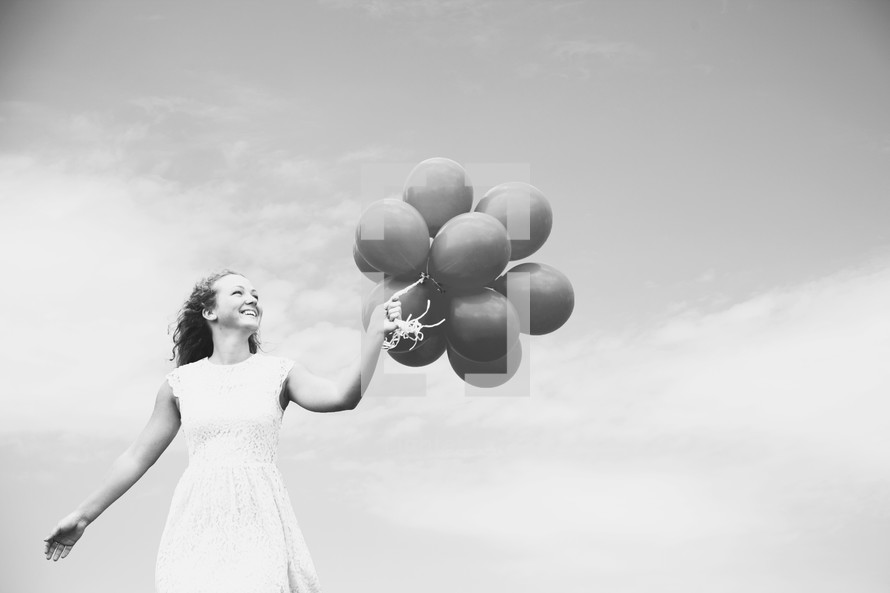 teenage girl holding balloons