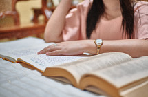 a young woman reading a Bible and taking notes 