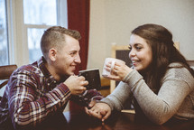 a couple holding hands drinking coffee