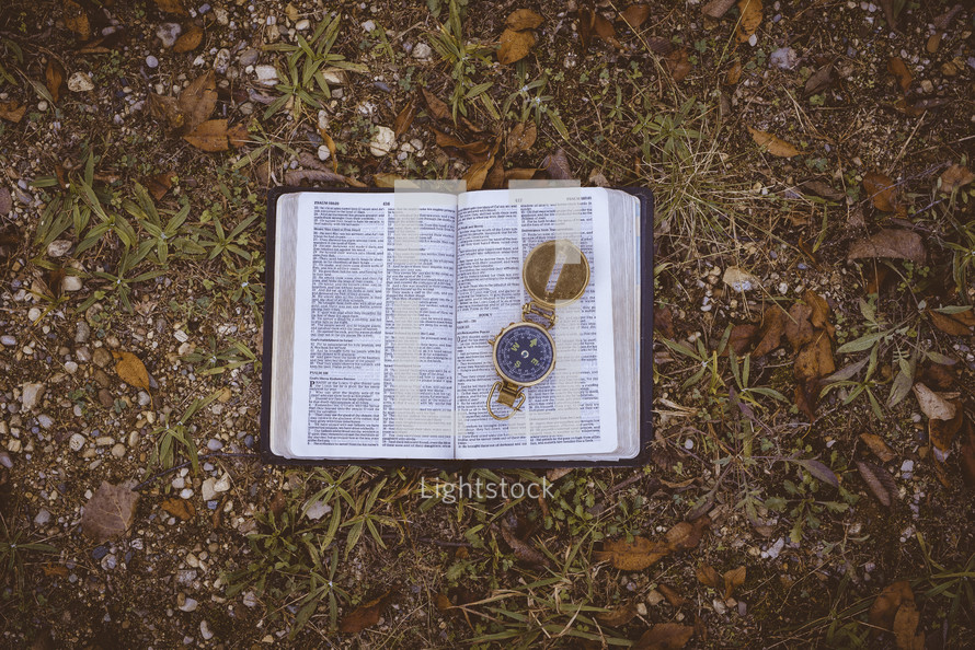 compass on the pages of a Bible 