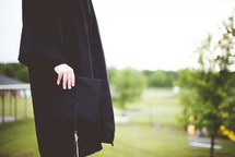 graduate holding a graduation cap 
