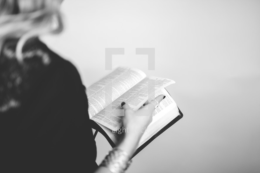 woman standing reading a Bible 