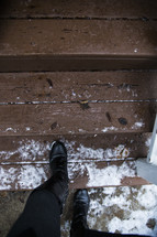 feet of a man walking up steps in the snow 