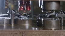Close up of a punch press forming metal parts in a production line