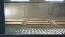 Automated wood painting robot spraying wood plates in a furniture production facility