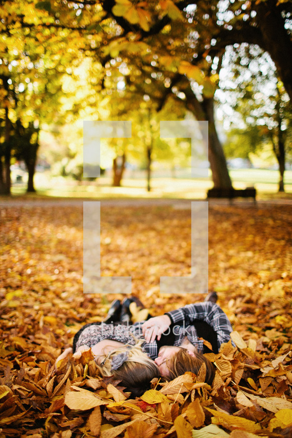 Couple lying in Fall leaves