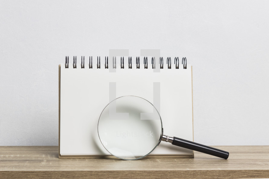 blank paper and magnifying glass 
