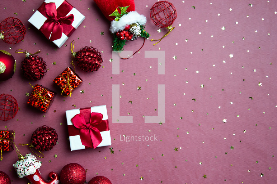 Christmas theme with gift boxes, ornaments over the red background.