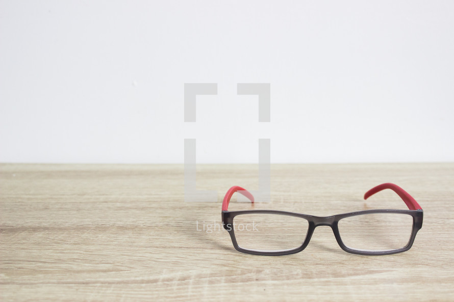 reading glasses on a wood table 