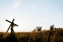 man carrying the cross through a field 