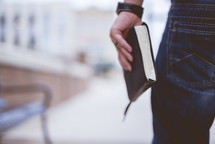man carrying a Bible at his side