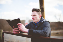 man reading a Bible on a ranch 