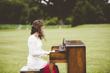 girl playing a piano outdoors 