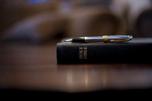 Bible and pen on a wood desk 