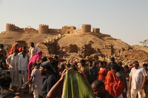 gathering of people in front of an old fortress 