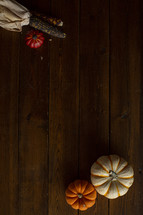 pumpkins and fall corn on a wood background 