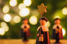 wooden figurines and bokeh Christmas lights 