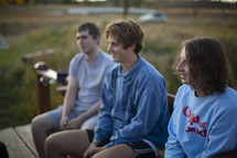 young adults sitting outdoors talking 
