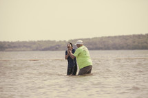 baptism of a woman in lake water 