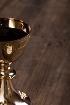 A golden communion goblet filled with wine.