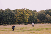 daughter running to her father in a meadow 