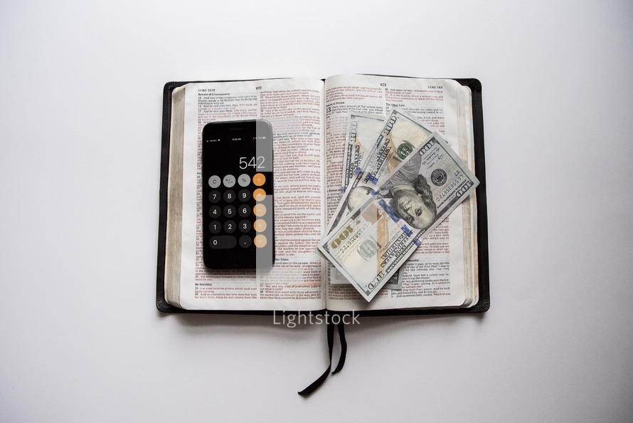 calculator and money on a Bible 