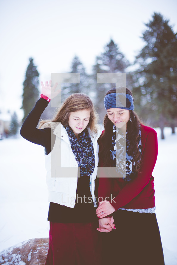 women praying outdoors in winter 