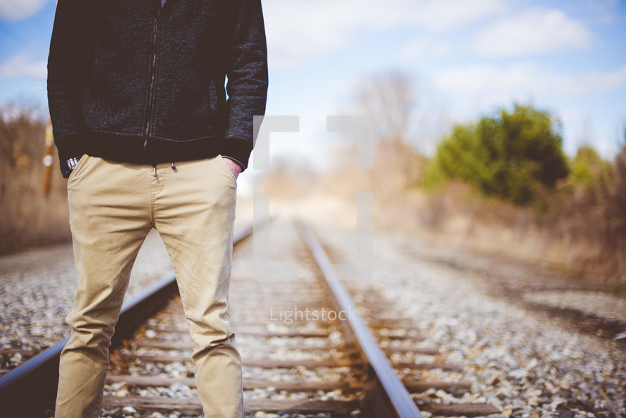 a man standing in the middle of train tracks