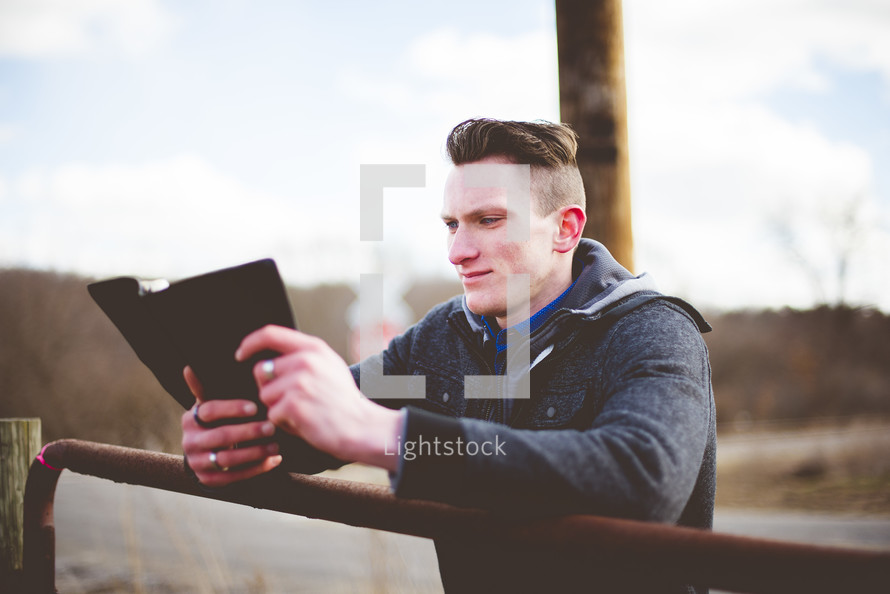 man reading a Bible on a ranch 