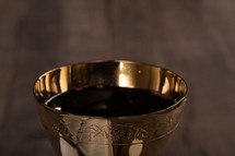 A golden goblet filled with wine.