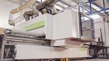 Automated wood processing machine in a furniture manufacturing facility