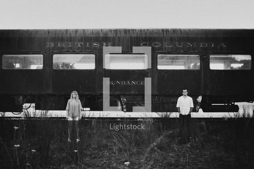 man and woman standing in front of an old railway car