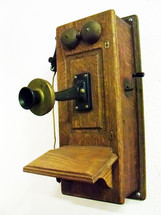 An old vintage telephone made out of wood and metal from the late 1800s. This was one of the first telephone designs invented back in the late 1800s. 