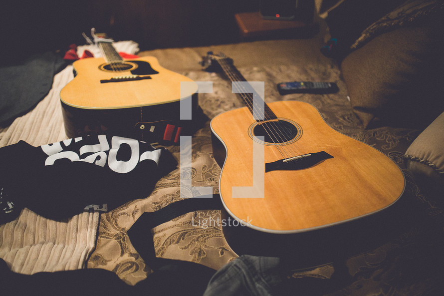 guitars resting on a bed 