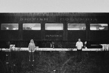 man and woman standing in front of an old railway car