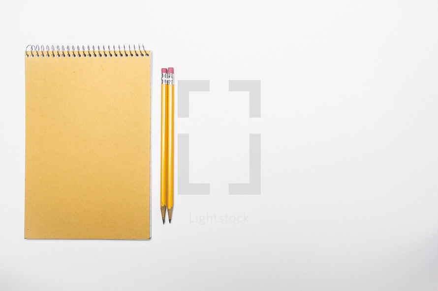 two pencils and a spiral notebook 