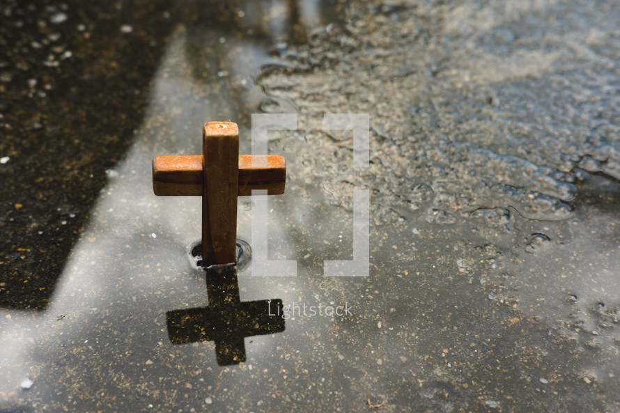 wooden cross in a puddle 