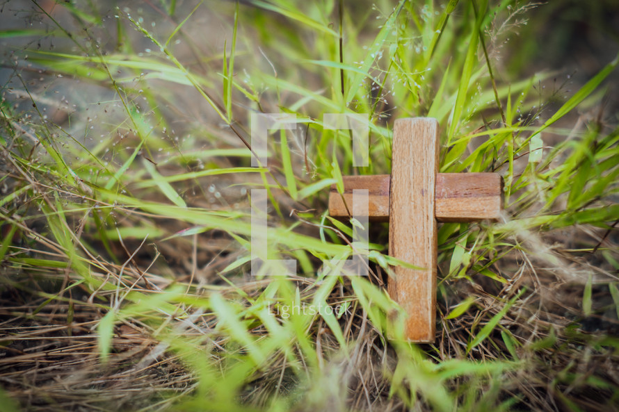 small wooden cross in grass